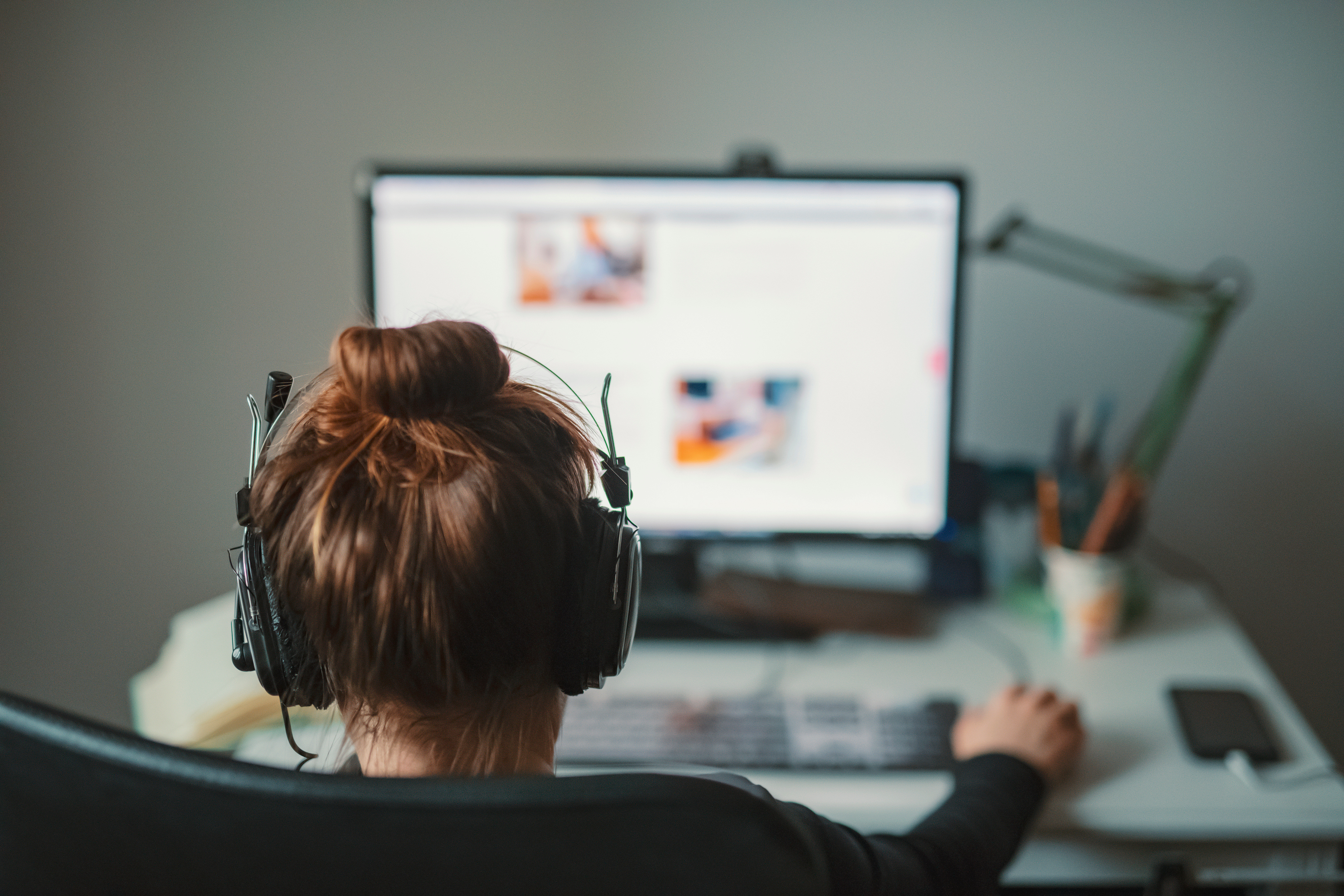 Femme qui télétravail de chez elle sur un bureau.