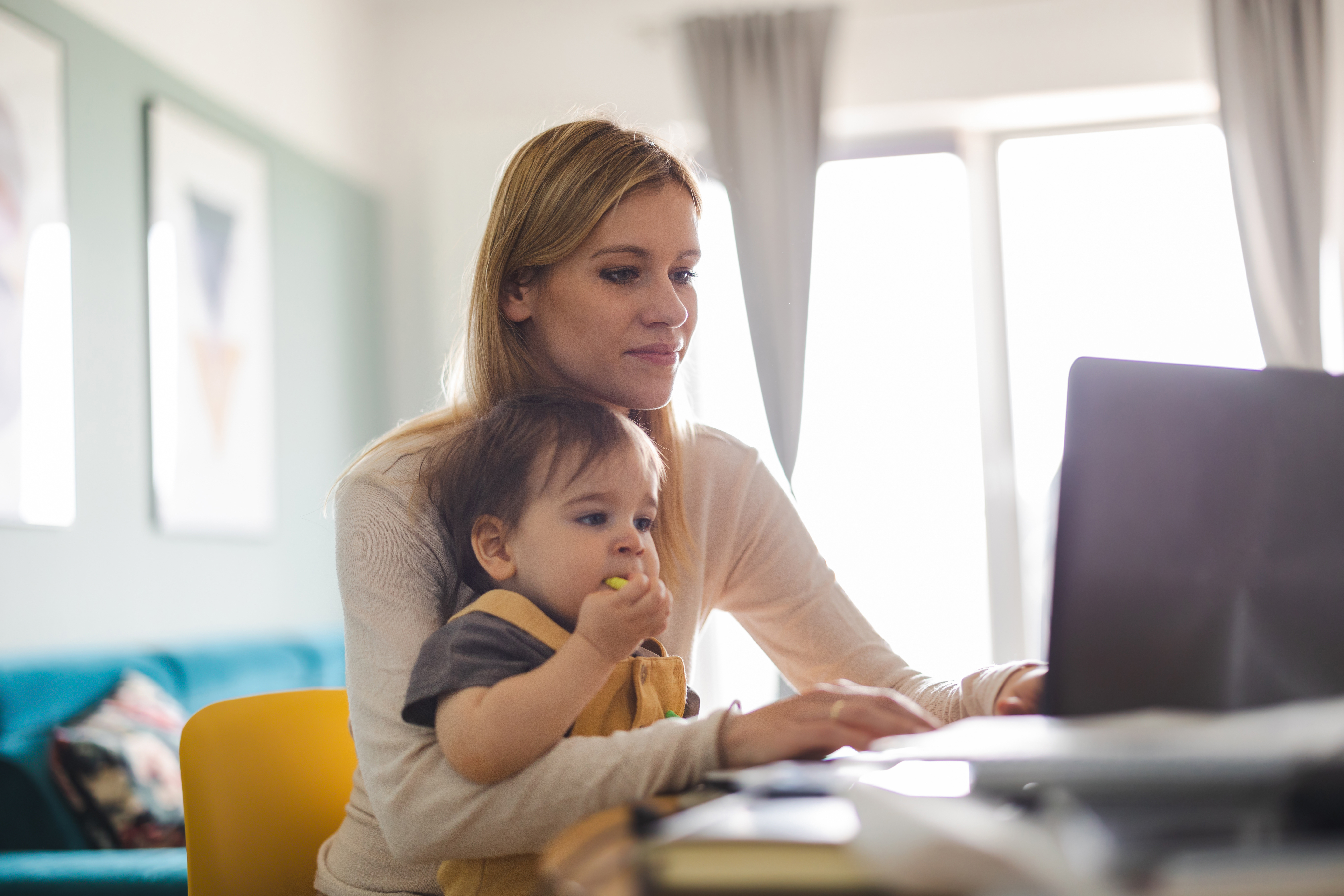 Femme avec son enfant qui télétravail.